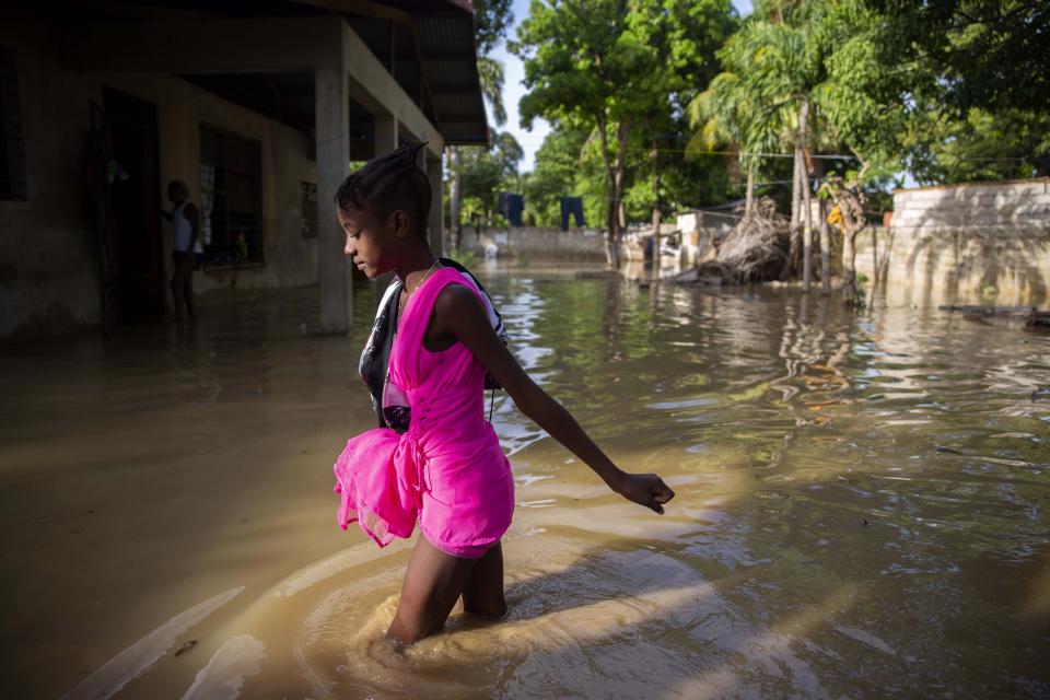 A girl wades towards her flooded home the day after the passing of Tropical Storm Laura in Port-au-Prince, Haiti, Monday, Aug. 24, 2020. Laura battered the Dominican Republic and Haiti on it's way to the U.S. Gulf Coast, where forecaster fear it could become a major hurricane. (AP Photo/Dieu Nalio Chery)