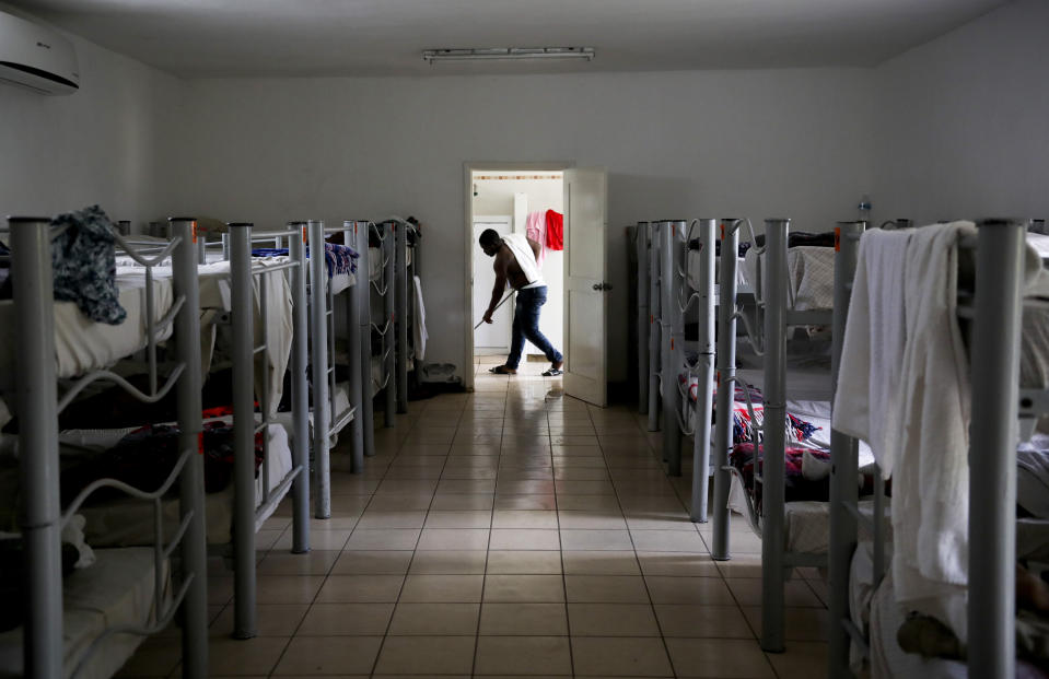 A migrant from Cameroon cleans the floor of "La Casa del Migrante" shelter for migrants in Matamoros, Mexico, Thursday, Aug. 1, 2019, on the border with Brownsville, Texas. The United States government has sent some 800 mostly Central American and Cuban immigrants back to this northern Mexico border city since expanding its controversial plan to this easternmost point on the shared border two weeks ago, according to local Mexican authorities. (AP Photo/Emilio Espejel)