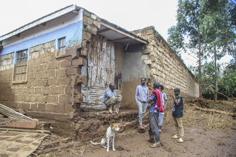 People gather near a damaged house after a dam burst in Kamuchiri Village Mai Mahiu, Nakuru County, Kenya, Monday, April. 29, 2024. Kenya's Interior Ministry says at least 45 people have died and dozens are missing after a dam collapsed following heavy rains. (AP Photo/Patrick Ngugi)