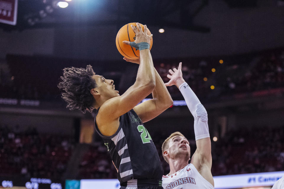 Chicago State's Jahsean Corbett (24) shoots against Wisconsin's Tyler Wahl during the first half of an NCAA college basketball game Friday, Dec. 22, 2023, in Madison, Wis. (AP Photo/Andy Manis)