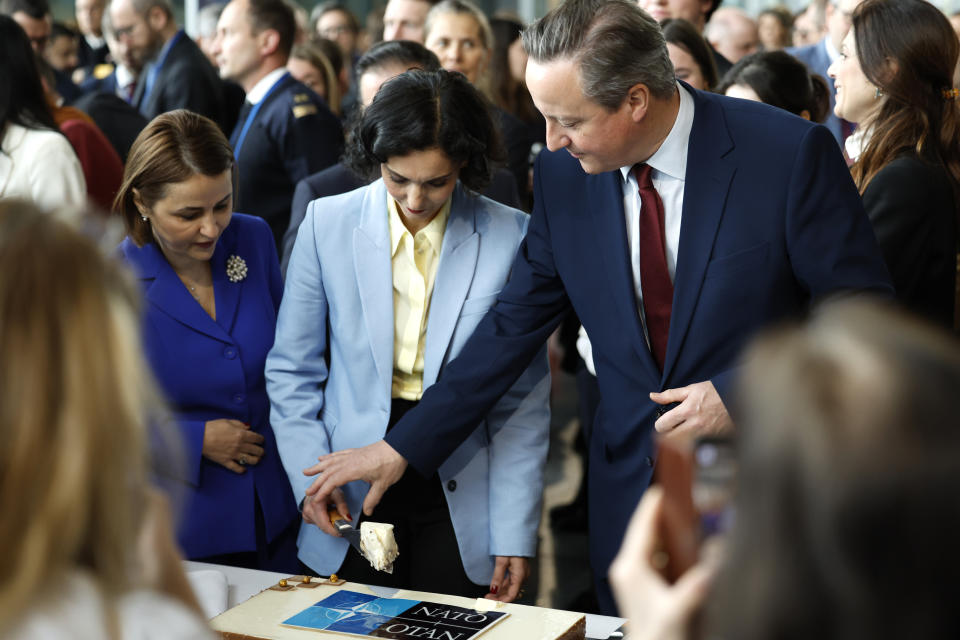 FILE - From left, Romania's Foreign Minister Luminita-Teodora Odobescu, Belgium's Foreign Minister Hadja Lahbib and British Foreign Secretary David Cameron cut a cake during a ceremony to mark the 75th anniversary of NATO at NATO headquarters in Brussels, Thursday, April 4, 2024. United States President Joe Biden and his counterparts meet in Washington for a three-day summit beginning Tuesday, July 9, 2024 to mark the military alliance's 75th anniversary, with Russian troops pressing their advantave along Ukraine's eastern front in the third year of war. (AP Photo/Geert Vanden Wijngaert, File)