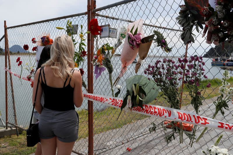 A man looks at a memorial at the harbour in Whakatane, following the White Island volcano eruption in New Zealand