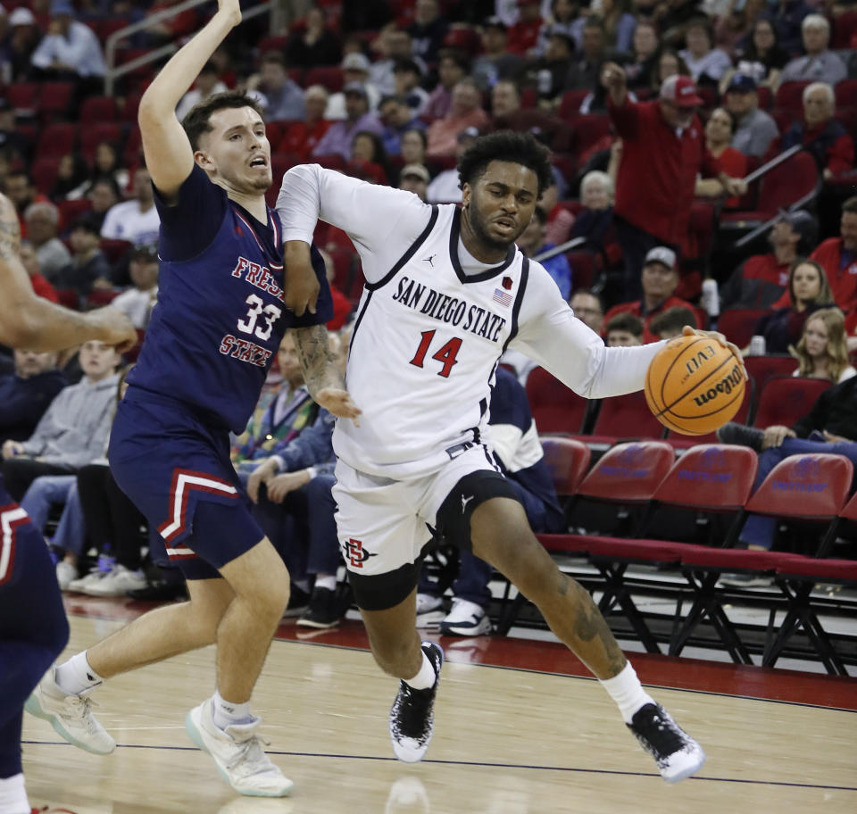San Diego State guard Reese Waters drives against Fresno State's Steven Vasquez Jr. during the first half of an NCAA college basketball game in Fresno, Calif., Saturday, Feb. 24, 2024. (AP Photo/Gary Kazanjian)