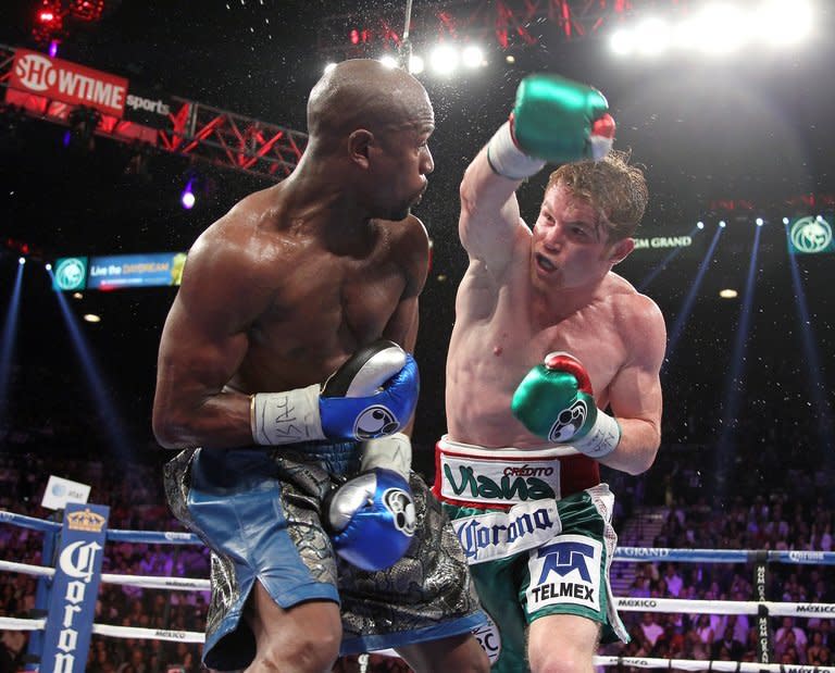 Saul Alvarez (R) throws a right at Floyd Mayweather during their WBC/WBA super welterweight fight at the MGM Grand Garden Arena in Las Vegas on September 14, 2013