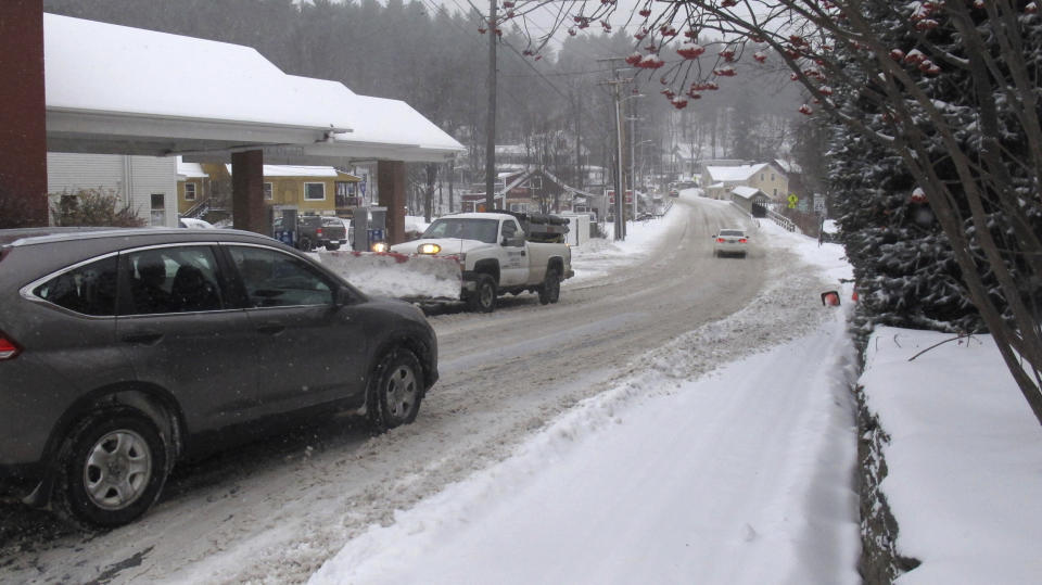 Vehicles make their way on a snow-covered street of Stowe, Vt., on Tuesday, Nov. 12, 2019. In the first significant snow of the season, a wintry mix swept into northern New England, with hundreds of schools closed or delayed in Vermont due to snow, and slick conditions in New Hampshire and Maine. The National Weather Service says record cold could follow the snow. (AP Photo/Wilson Ring)