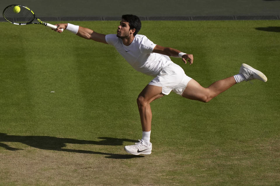 Spain's Carlos Alcaraz returns to Denmark's Holger Rune in a men's singles match on day ten of the Wimbledon tennis championships in London, Wednesday, July 12, 2023. (AP Photo/Alberto Pezzali)