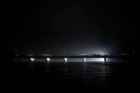 Migrants from Central America en route to the U.S stand on the bridge which divides Mexico and Guatemala, in Ciudad Hidalgo, Mexico, October 28, 2018. REUTERS/Carlos Garcia Rawlins