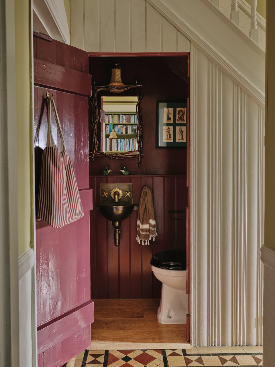 Tucked under the stairs is an eggplant-toned powder room with a vintage sink and other equally characterful curiosities.