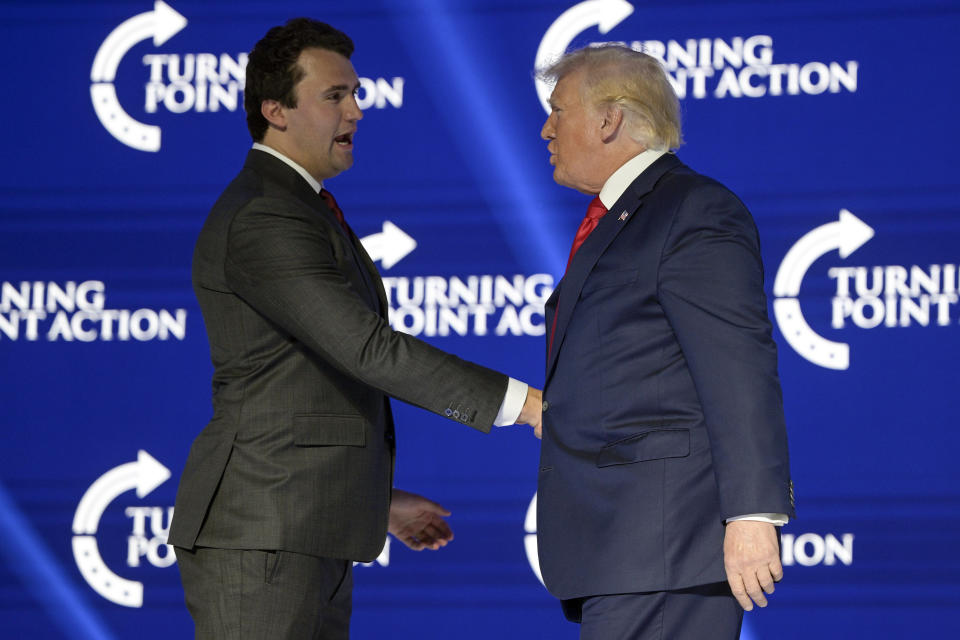 FILE - Former President Donald Trump, right, shakes hands with Turning Point CEO Charlie Kirk before speaking during the Turning Point USA Student Action Summit, July 23, 2022, in Tampa, Fla. The Nebraska Republican Party, currently led by Trump loyalists, will hold a rally Tuesday, April 9, 2024, in Omaha, Neb., featuring conservative activist Kirk to target the state's atypical system of splitting its five presidential electoral votes based on the popular vote within its congressional districts. (AP Photo/Phelan M. Ebenhack, File)