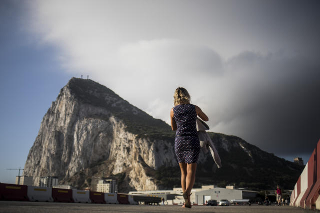 Backdropped by the Gibraltar rock, a woman crosses the Gibraltar airport runway, Thursday, June, 24, 2021. Gibraltar is holding a referendum on whether to introduce exceptions to the British territory's ban on abortion. Abortion is illegal in Gibraltar, unless it is needed to save the mother's life. Abortion is legally classified as "child destruction" and is punishable by up to life in prison. (AP Photo/Javier Fergo)
