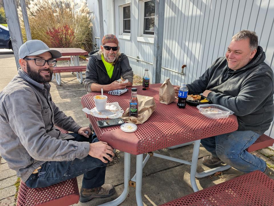 Dustin Gray, left, Dean Davis and Eric Runion take a break from their construction jobs to grab chicken lunches at Roots Poultry. They are fans of the new ready-made hot meals and deli.
