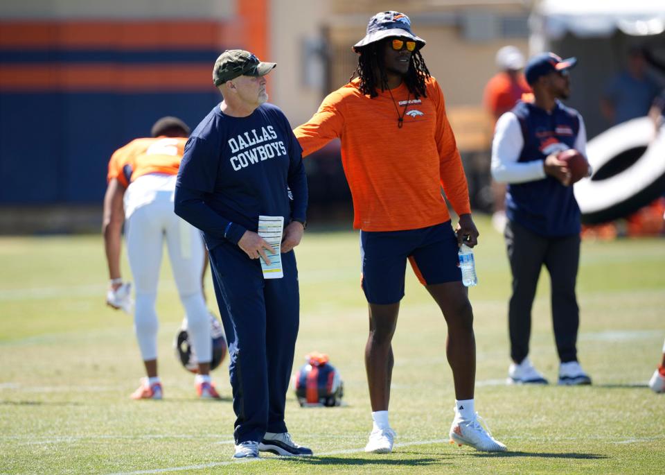 Denver Broncos linebacker Randy Gregory, right, greets Dallas Cowboys defensive coordinator Dan Quinn during NFL football practice Thursday, Aug. 11, 2022, in Centennial, Colo.