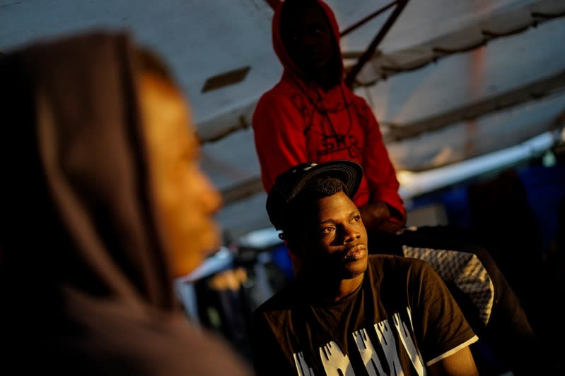 Migrants rest on board of NGO Proactiva Open Arms rescue boat in central Mediterranean Sea