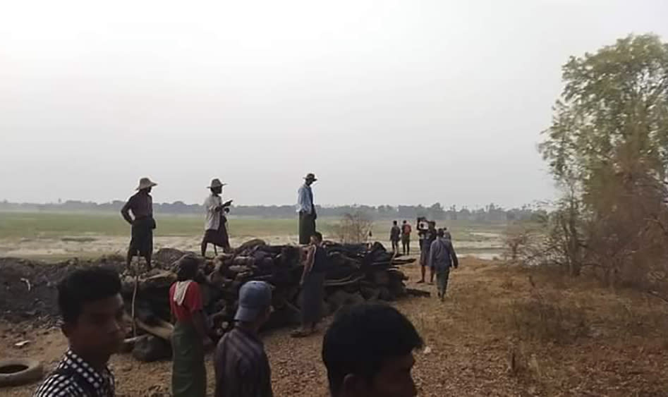 Men stand over a funeral pyre in Tar Taing village, as they prepare to cremate bodies of those found dead in the nearby village of Nyaung Yin, Myinmu township and in Tar Taing village, Sagaing township, central Myanmar on Thursday, March 2, 2023. Soldiers in Myanmar rampaged through several villages, raping, beheading and killing at least 17 people, residents said, in the latest of what critics of the ruling military say are a series of war crimes since the army seized power two years ago. (UGC via AP)