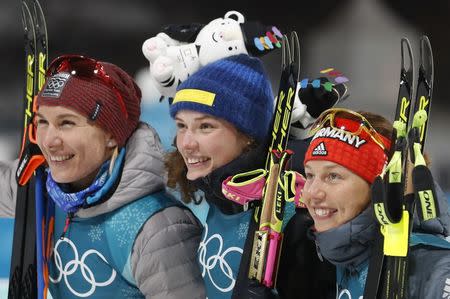 Biathlon - Pyeongchang 2018 Winter Olympics - Women's 15km Individual Final - Alpensia Biathlon Centre - Pyeongchang, South Korea - February 15, 2018 - Gold medalist Hanna Oeberg of Sweden, silver medalist Anastasiya Kuzmina of Slovakia and bronze medalist Laura Dahlmeier of Germany pose during the victory ceremony. REUTERS/Murad Sezer