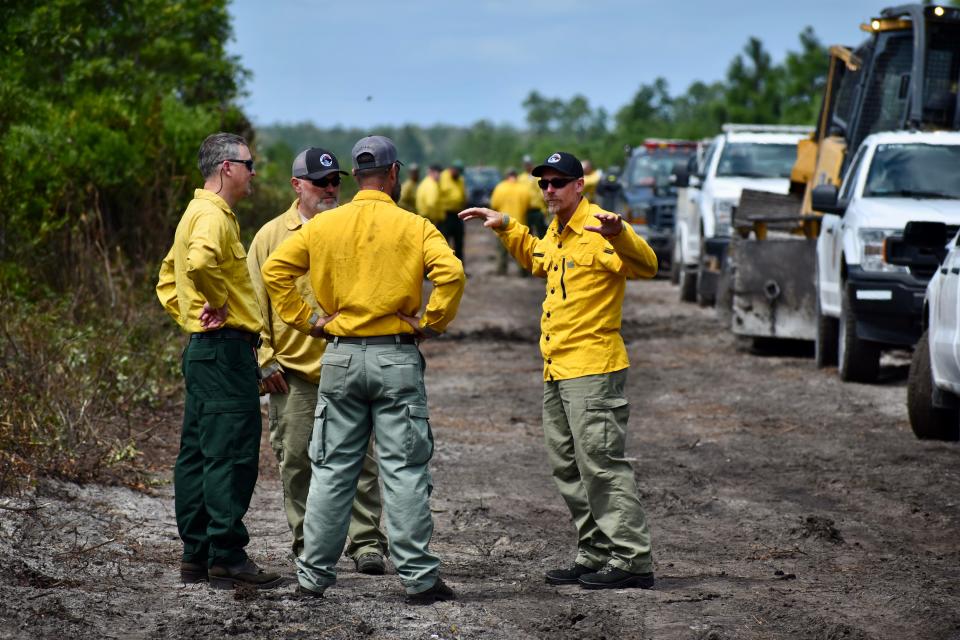 Shane Hardee (right), District 8 forester and deputy incident commander with the North Carolina Forest Service, debriefs with his team at the site of the Juniper Road Two Fire on Wednesday, Aug. 17, 2022.