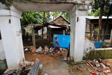 A boy walks past the entrance of a destroyed mosque after a group of men attacked it in the first serious outburst of inter-religious violence in months in the village of Thayethamin outside Yangon, Myanmar June 24, 2016. REUTERS/Soe Zeya Tun