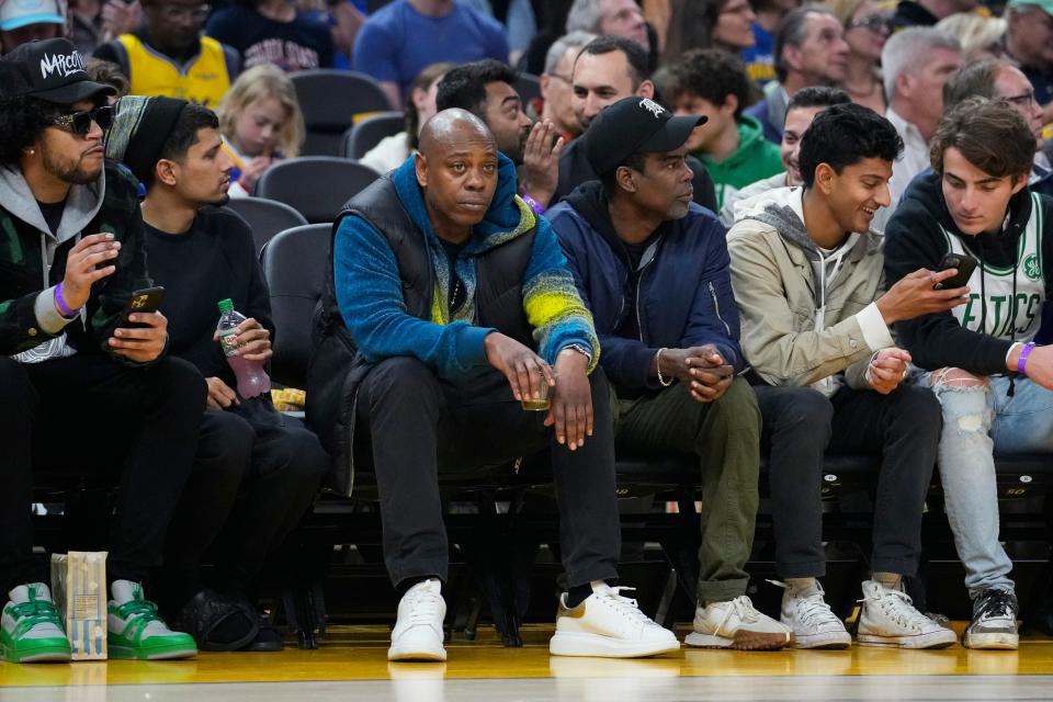 Comedians Dave Chappelle, middle left, and Chris Rock, middle right, sit courtside during the first half of an NBA basketball game between the Golden State Warriors and the Boston Celtics in San Francisco, Saturday, Dec. 10, 2022. (AP Photo/Godofredo A. Vásquez)
