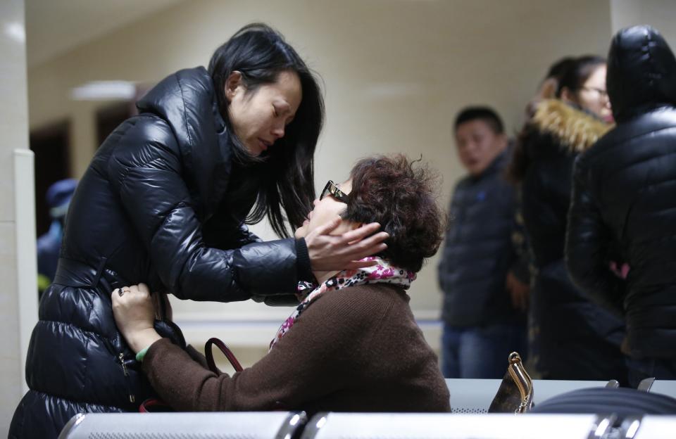 Relatives of a victim hug as they wait at a hospital where injured people of a stampede incident are treated in Shanghai