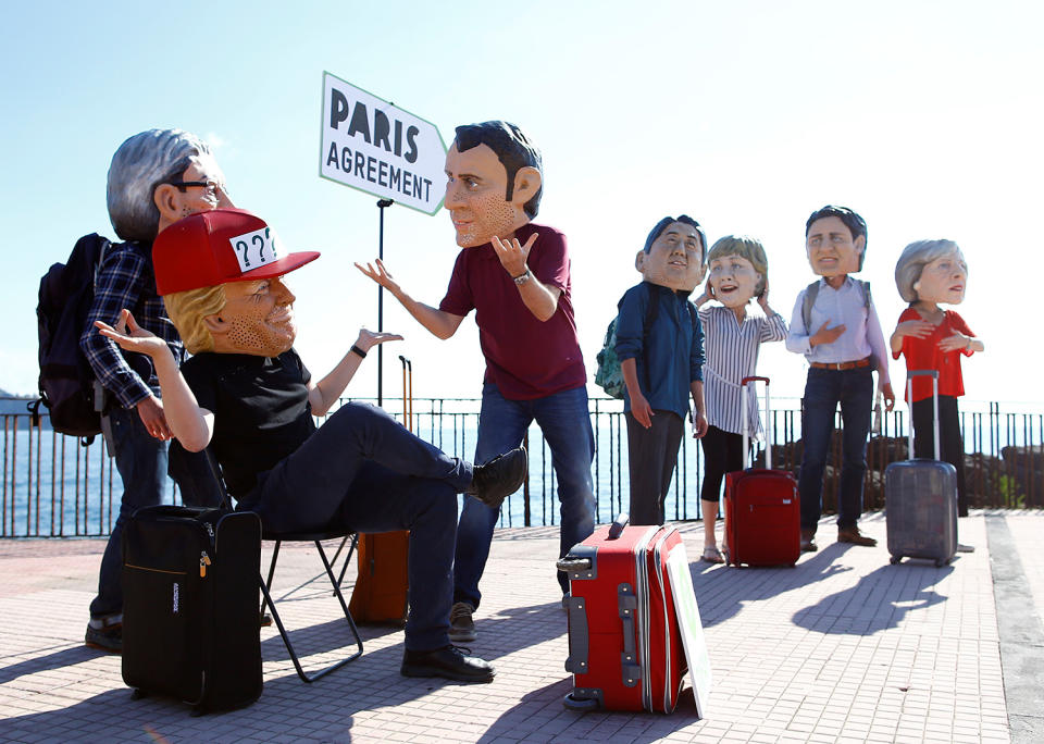 Protesters wear masks depicting the leaders of the G-7 countries during a demonstration