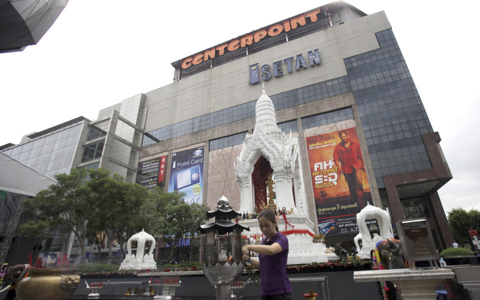 In this photo taken Friday, June 15, 2012, a woman prays to a Buddhist statue in front of a shopping mall in Bangkok. There was a time when Buddhist pilgrims would journey thousands of miles on foot to seek enlightenment, what is known to the faithful as "dharma." Last week, anyone looking for a taste of enlightenment could make one's way to a modern mega-mall in downtown Bangkok to grab a seat in a modern air-conditioned movie theater. Some promoters brought 36 films with Buddhist themes to the heart of modern Thailand earlier this month. (AP Photo/Sakchai Lalit)