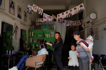 Ethnic Lisu people stand inside a barber shop in Daxindi township of Nujiang Lisu Autonomous Prefecture in Yunnan province, China, March 24, 2018. REUTERS/Aly Song