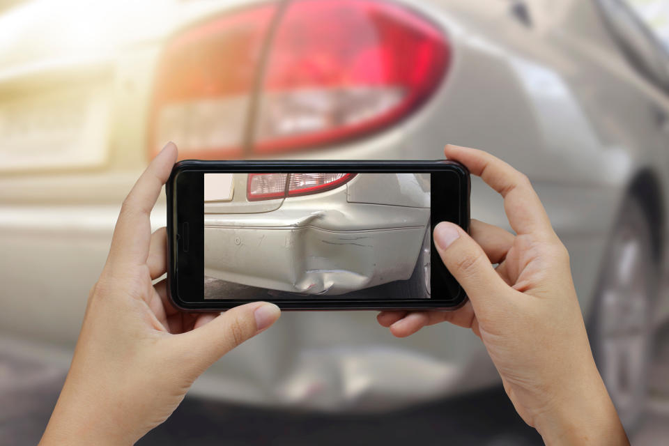 Cropped Hands Photographing Damaged Car With Smart Phone