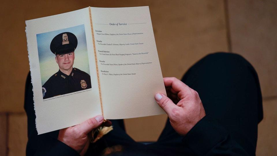 PHOTO: A U.S. Capitol Police Officer holds a program for the ceremony memorializing Police Officer Brian D. Sicknick, 42, as he lies in honor in the Rotunda of the Capitol, Feb. 3, 2021, in Washington. (Demetrius Freeman/Pool/Getty Images)