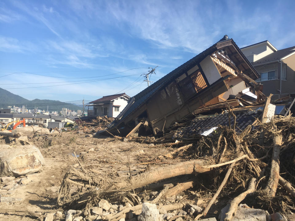 Damaged houses and a mud-covered road in the aftermath of heavy rains in Hiroshima, southwestern Japan. (Photo: ASSOCIATED PRESS)