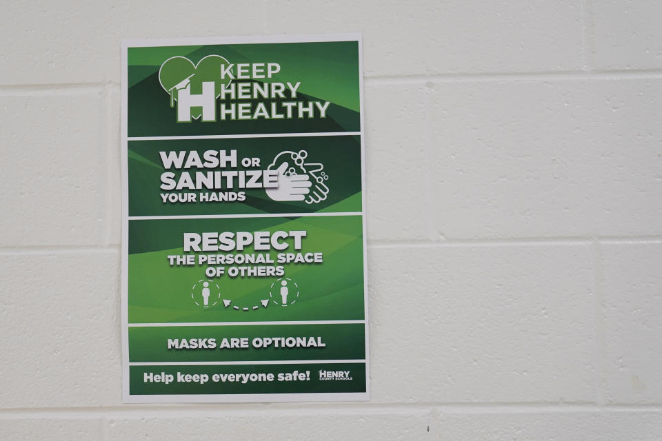 A sign hanging in the hallway reads "Keep Henry Healthy, wash or sanitize your hands, repeat the personal space of others and masks are optional" at Tussahaw Elementary school on Wednesday, Aug. 4, 2021, in McDonough, Ga. Schools have begun reopening in the U.S. with most states leaving it up to local schools to decide whether to require masks. (AP Photo/Brynn Anderson)