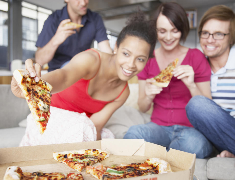 Friends sharing delivered pizza.