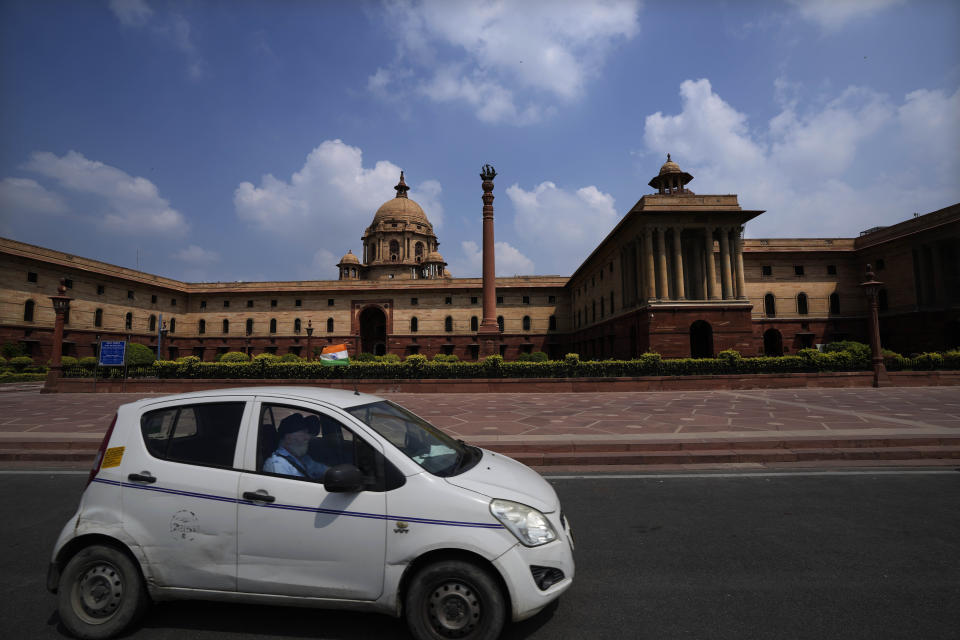 A taxi carrying national flag drives past colonial building which houses important ministries in New Delhi, India, Sunday, Sept. 11, 2022. India, once the largest of Britain’s colonies that endured two centuries of imperial rule has moved on. Queen Elizabeth II’s death provoked sympathies from some while for a few others, it jogged memories of a bloody history under the British crown. Among most regular Indians, the news was met with an indifferent shrug. (AP Photo/Manish Swarup)