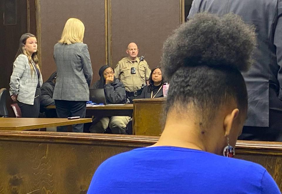 Defendant Anna Stecenko, left, stands at her sentencing for evidence tampering in the murder of Jaylin Jaquan “Bart” Williams, as Williams’ mother Angel King, in the foreground, looks down.