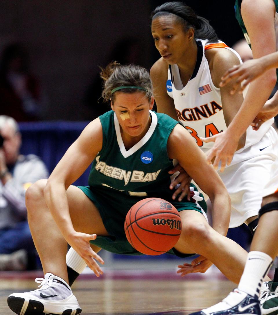 Wisconsin-Green Bay guard Julie Wojta picks up a loose ball in front of Virginia forward Britny Edwards, right, during the first half of an NCAA first-round college basketball tournament game, Sunday, March 21, 2010, in Ames, Iowa.