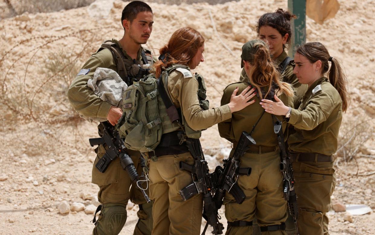 Israeli soldiers react to the news of the killings - Amir Cohen/Reuters