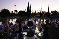 Invitados se congregan alrededor del busto del difunto actor Burt Reynolds, develado en el cementerio Hollywood Forever, en Los Ángeles, el lunes 20 de septiembre de 2021. Reynolds murió en 2018 a los 82 años. (AP Foto/Chris Pizzello)