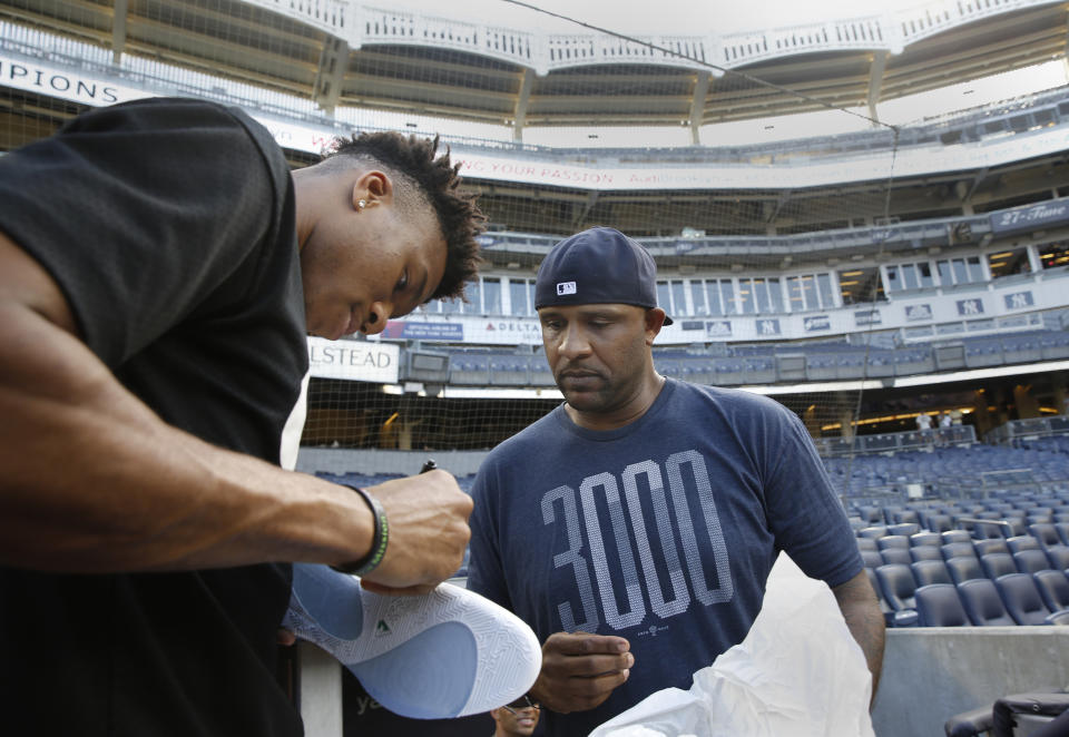 Milwaukee Bucks forward and 2019 NBA Most Valuable Player Giannis Antetokounmpo, left, signs shoes for New York Yankees starting pitcher CC Sabathia before a baseball game between the Yankees and the Tampa Bay Rays, Monday, July 15, 2019, in New York. (AP Photo/Kathy Willens)