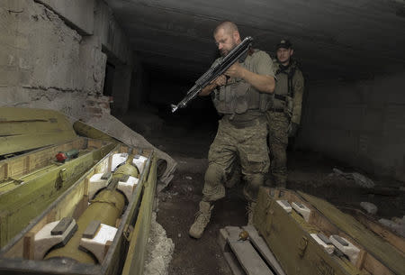 Members of Ukrainian police special task force "Kiev-1" inspect weapons hidden by pro-Russian separatists in the basement of an unfinished house in Slaviansk September 2, 2014. REUTERS/Stanislav Belousov