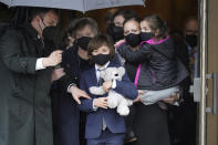 Logan Evans, 9, center, son of the late U.S. Capitol Police officer William "Billy" Evans, holds a stuffed toy as he departs St. Stanislaus Kostka Church with his grandmother Janice Evans, behind center left, and his mother Shannon Terranova, center right, who holds his sister Abigail Evans, 7, right, following a funeral Mass for his father, in Adams, Mass., Thursday, April 15, 2021. Evans, a member of the U.S. Capitol Police, was killed on Friday, April 2, when a driver slammed his car into a checkpoint he was guarding at the Capitol. (AP Photo/Steven Senne)