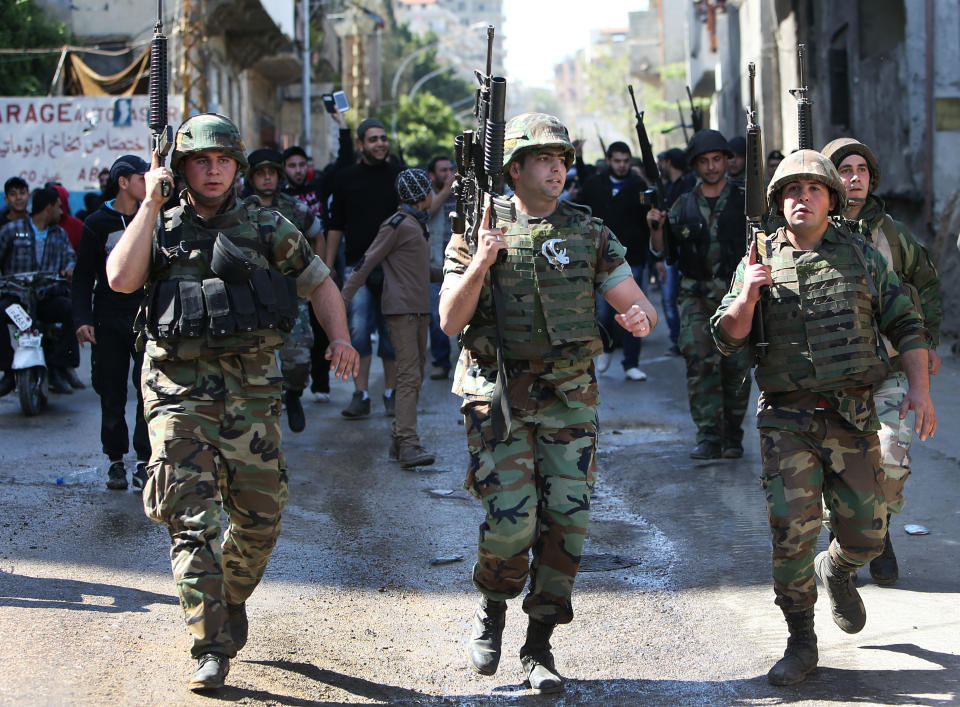 Lebanese army soldiers deploy in the streets of the Sunni neighborhood of Bab Tabbaneh and the neighboring Jabal Mohsen, which is mostly populated by followers of the Alawite sect, in the northern port city of Tripoli, Lebanon, Wednesday April, 2, 2014. In a rare day of exuberant emotion, weary residents of two warring neighborhoods greeted each other with tears and cheers as hundreds of Lebanese soldiers deployed for the first time in years throughout the area, quelling violence between them that has killed at least 200 people in three years. The Lebanese army deployment in the northern city of Tripoli is the most determined plan yet by the government to bring peace to an area that was teetering into the neighboring Syrian civil war. (AP Photo/Hussein Malla)