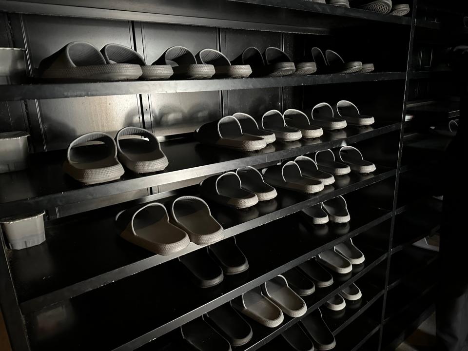 wall of slippers in dark room