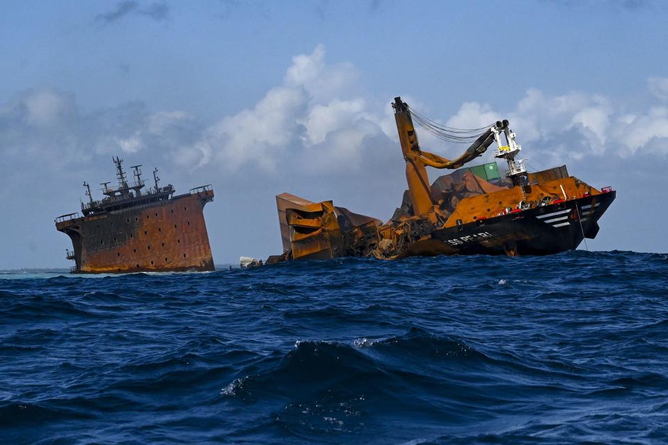 The fire stricken Singapore-registered container ship MV X-Press Pearl (L) is seen sinking while being towed away from the coast of Colombo, June 2, 2021, following Sri Lankan President Gotabaya Rajapaksa's order to move the ship to deeper water to prevent a bigger environmental disaster. / Credit: ISHARA S. KODIKARA/AFP/Getty