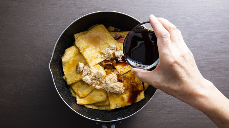 pouring soy sauce over tofu