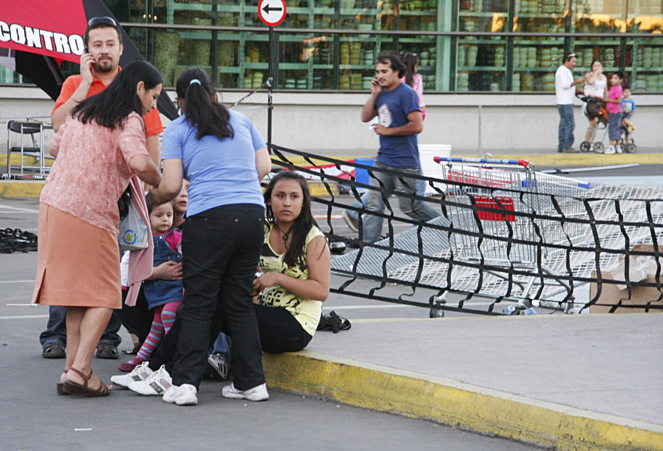 People gather outside a supermarket after an earthquake was felt in Talca, Chile, Sunday, March 25, 2012. A magnitude-7.2 earthquake has struck just off the coast of central Chile, prompting an emergency evacuation order for people living near the ocean in case it spawns a tsunami. (AP Photo/Fabian Suazo)