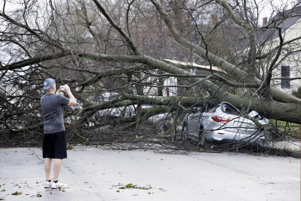 A resident photographs damage after a tornado touched down Tuesday, March 3, 2020, in Nashville, Tenn. (AP Photo/Mark Humphrey)