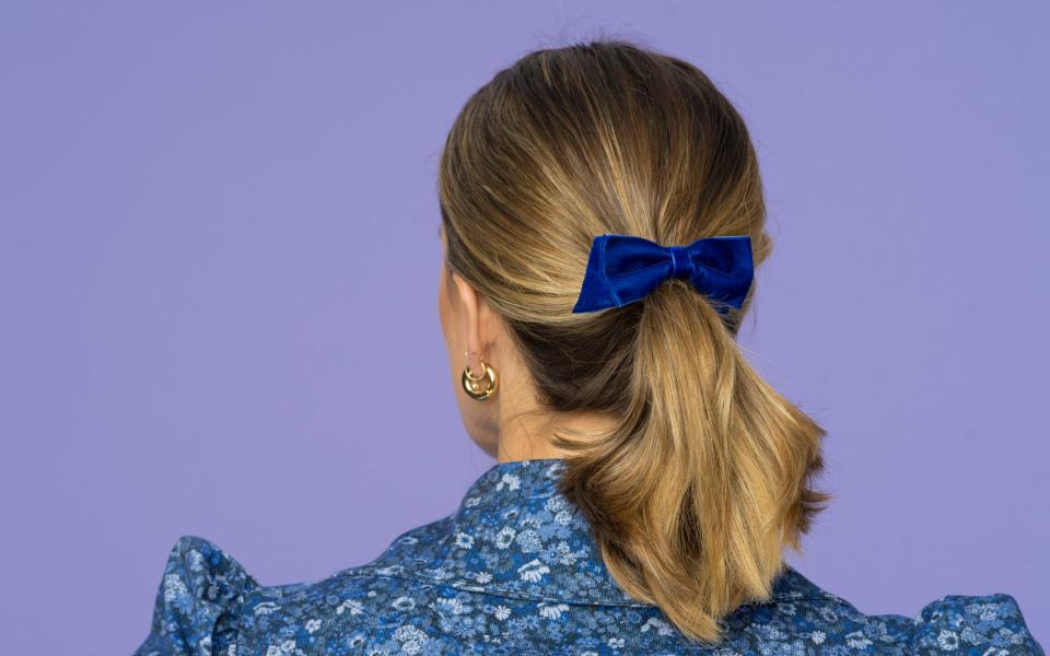 Little touches: Ginnie's velvet hair bow matches the bow on top