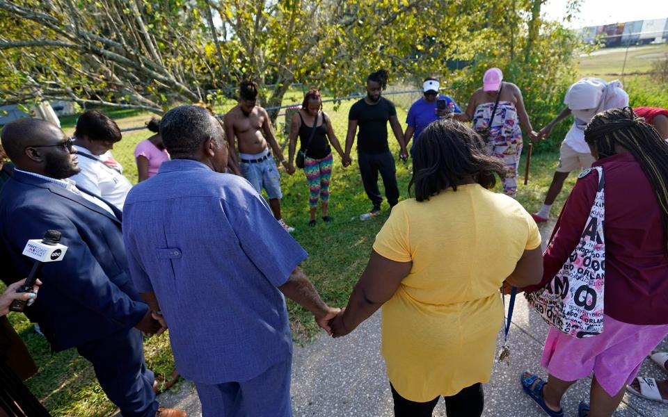 Residents gather for a prayer near the scene of a mass shooting at a Dollar General store