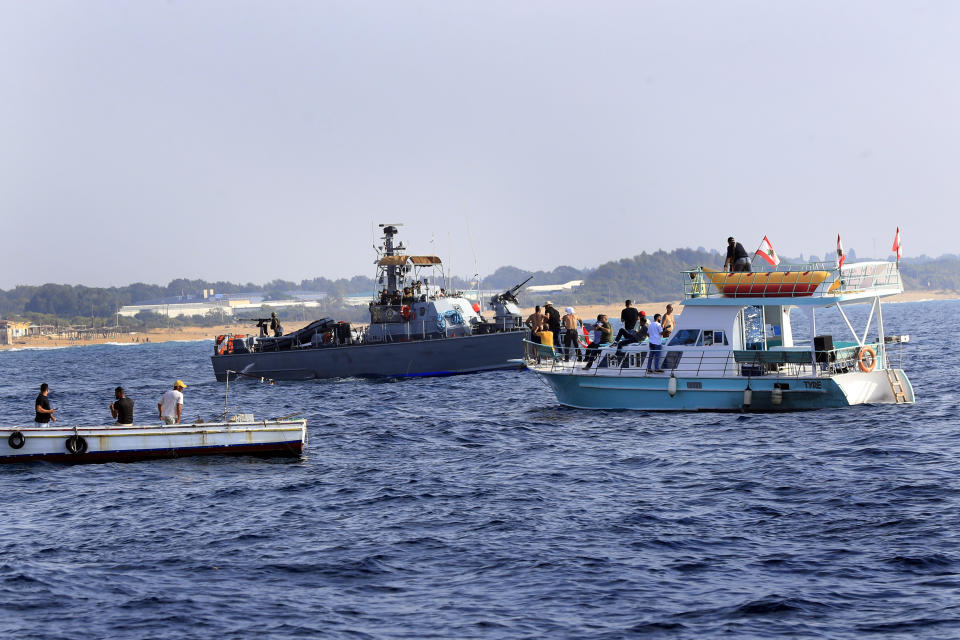 Lebanese protesters sail near an Israeli Navy vessel during a demonstration demanding Lebanon's right to its maritime oil and gas fields, in the southern marine border town of Naqoura, Lebanon, Sunday, Sept. 4, 2022. The protest came days before the mediating U.S. envoy is scheduled to land in Beirut to continue maritime border talks. (AP Photo/Mohammed Zaatari)