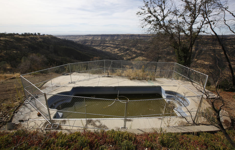 In this photo taken Thursday, Oct. 24, 2019, fencing surrounds a swimming pool at a home that was lost in last year's Camp Fire in Paradise, Calif. Only a handful of homes have been rebuilt in the community that lost nearly 9,000 residences in the fire. (AP Photo/Rich Pedroncelli)