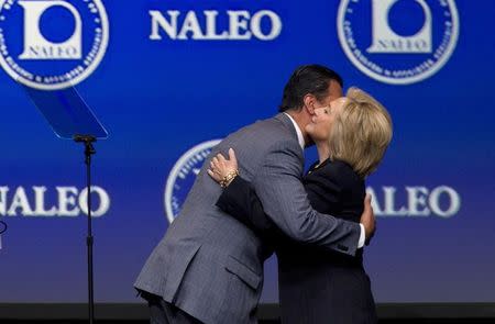 Former Secretary of State Hillary Clinton (R) is embraced by Alex Padilla, president of the National Association of Latino Elected and Appointed Officials (NALEO), as she arrives onstage to speak at the NALEO conference in Las Vegas, Nevada June 18, 2015. REUTERS/Steve Marcus